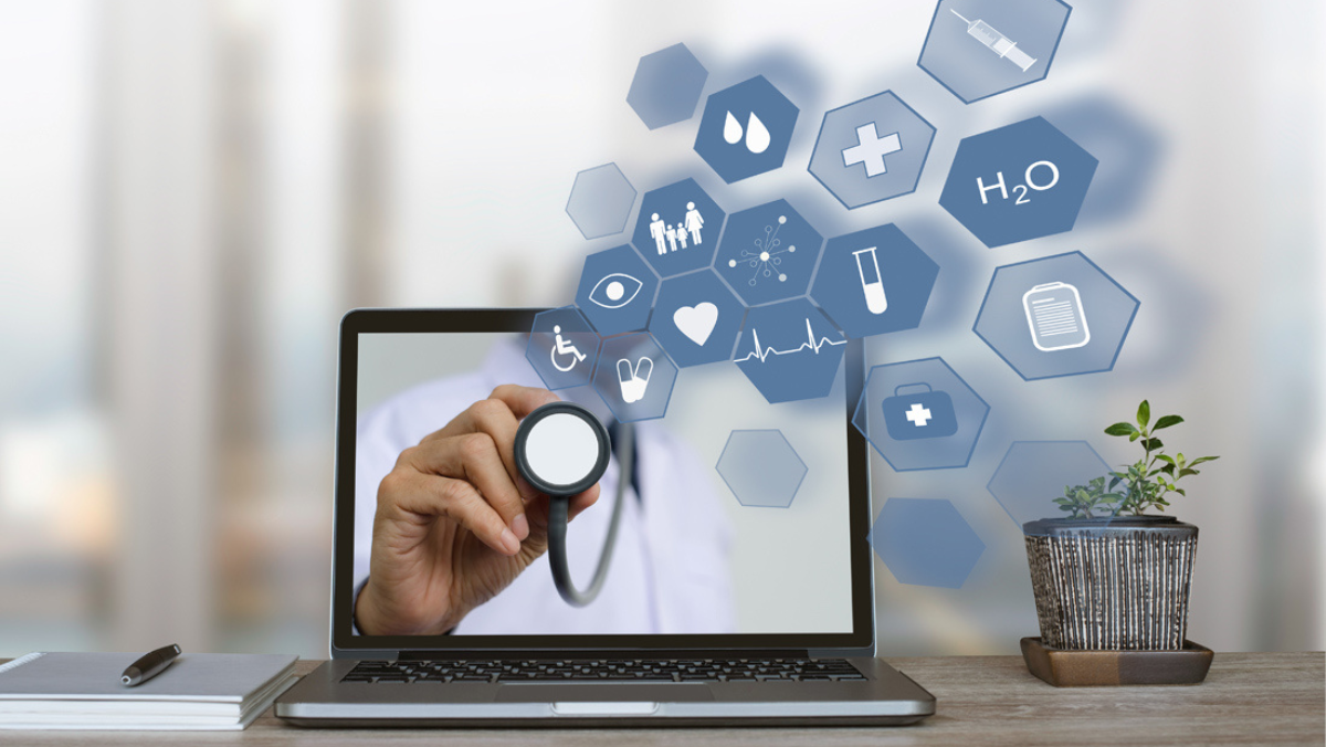 Doctor using a stethoscope through a laptop screen with digital health icons.